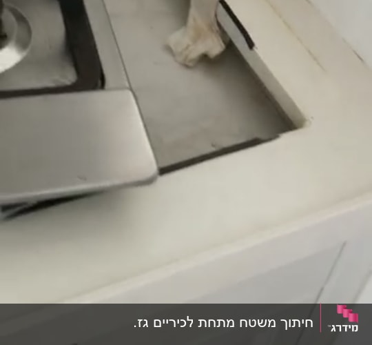 חיתוך שיש ליד כיריים במטבח